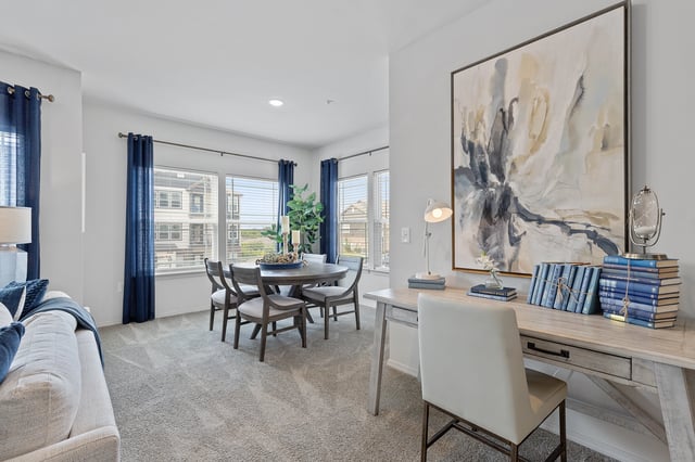 Dining area and home office space with desk, chair, and large artwork.