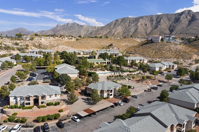 Aerial view of a desert apartment community with multiple buildings and a central pool.