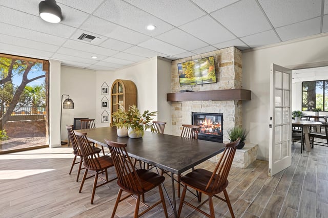 Community dining area with large table, fireplace, and TV.