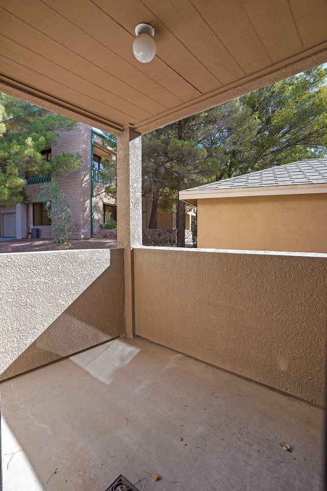 Empty patio with a light fixture and surrounding buildings.