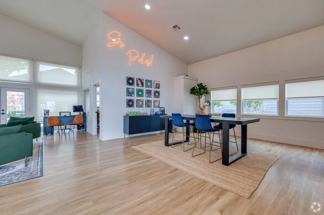 A coworking space with a high table and chairs, and a reception area.