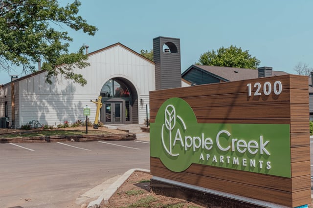 Exterior view of Apple Creek Apartments sign at the entrance.