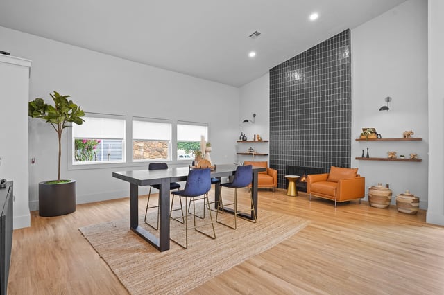 Modern dining area with a large table and chairs, fireplace, and contemporary decor.