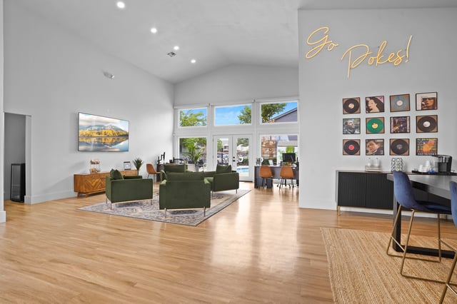 Spacious resident lounge with modern furniture, artwork, and large windows overlooking the pool.