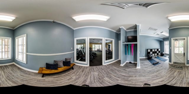 Fitness center with cardio machines, free weights, yoga mats, and exercise balls.