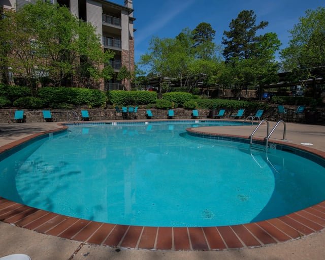 A round swimming pool with blue water and a brick border.