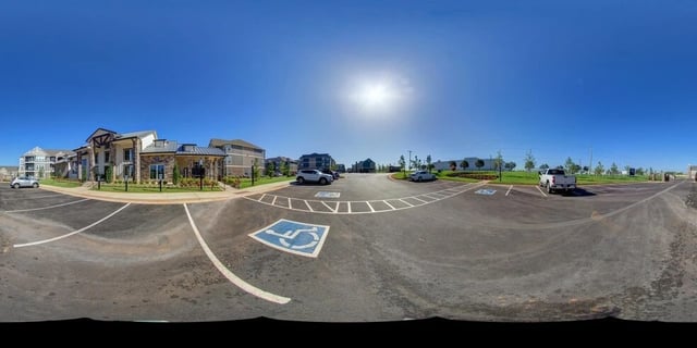 Parking lot with accessible parking spaces and apartment buildings in the background.