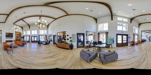 Spacious lobby with vaulted ceilings, exposed beams, modern lighting, and seating areas.