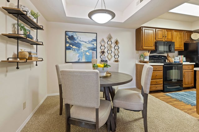 A dining room with a table and chairs.