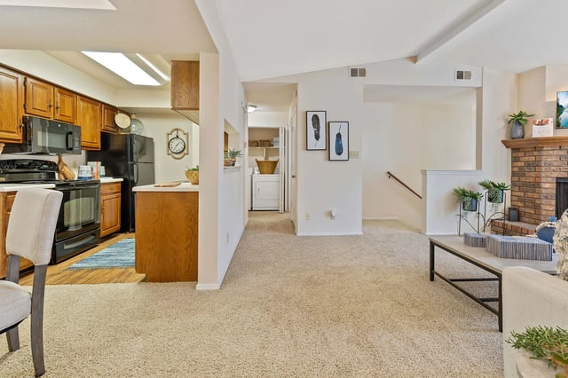 A living room with a couch, a chair, and a fireplace.
