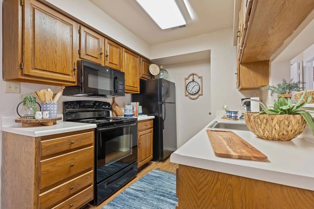 A kitchen with wooden cabinets and black appliances.
