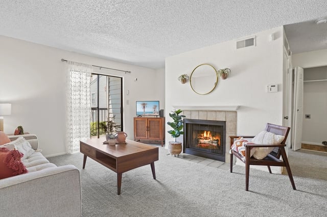 Living room with a fireplace, coffee table, and sofa.