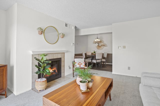 Living room with a fireplace and a dining area in the background