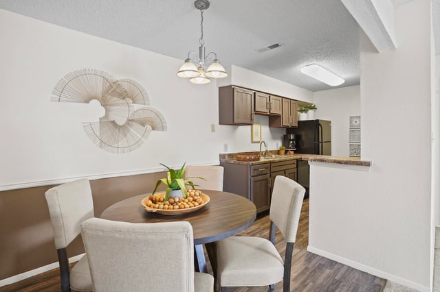 Dining area and kitchen with dark wood cabinets and stainless steel appliances.