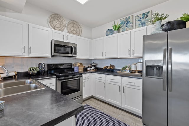 A kitchen with white cabinets and stainless steel appliances.