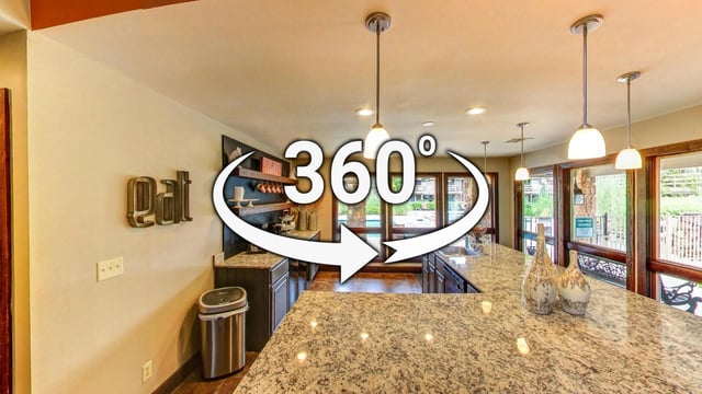 360-degree view of a modern apartment kitchen with granite countertops and stainless steel appliances.