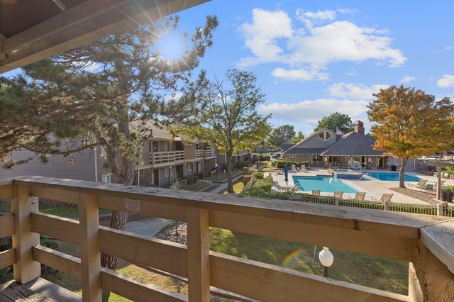 View of the outdoor swimming pool and clubhouse area from a balcony.