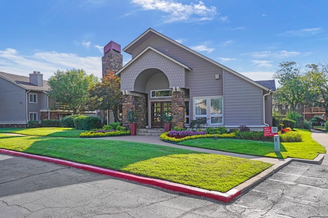 Apartment building entrance with stone facade and arched entryway.