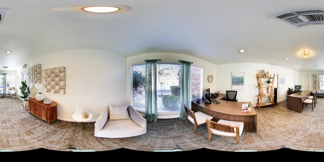 Reception desk and seating area in apartment complex lobby.