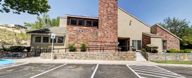 Building exterior with brick and siding, entrance, and parking.
