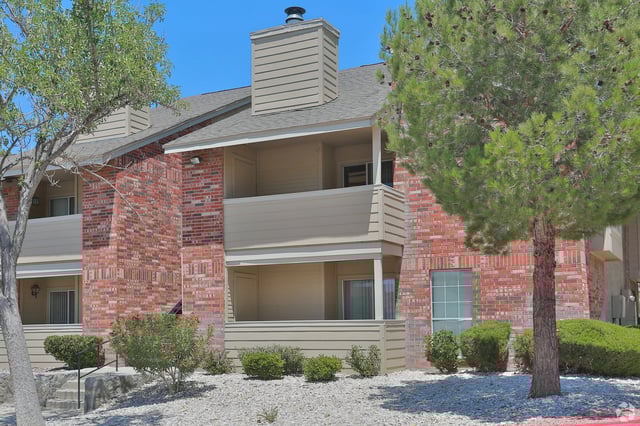 Brick apartment building with tan siding and balconies.