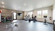 Gym with treadmills, elliptical machines, weight bench, and weights.