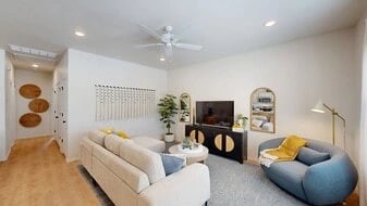 Living room with sofa, chair, tv, and ceiling fan