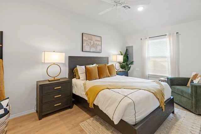 Stylish bedroom with a queen-size bed, bedside tables with lamps, and a comfortable armchair.