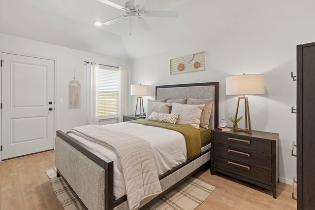 A modern bedroom with a king-sized bed, nightstand, and dresser.