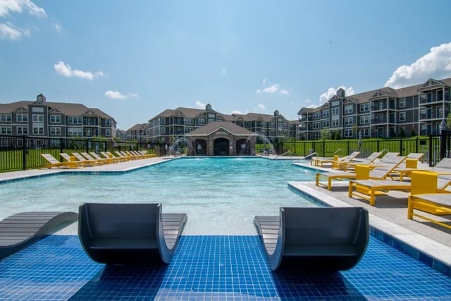 Lounge chairs overlooking a pool with fountains.