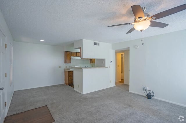 Living room and kitchen area with a ceiling fan.