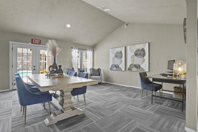 Community lounge area with a dining table, seating, and a workspace.