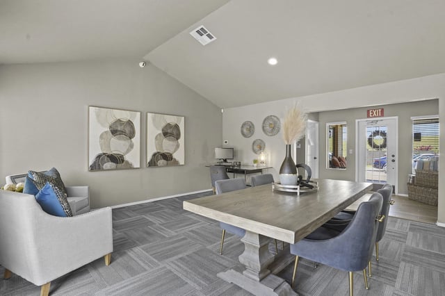 Modern communal dining and workspace area with comfortable seating and decorative art.