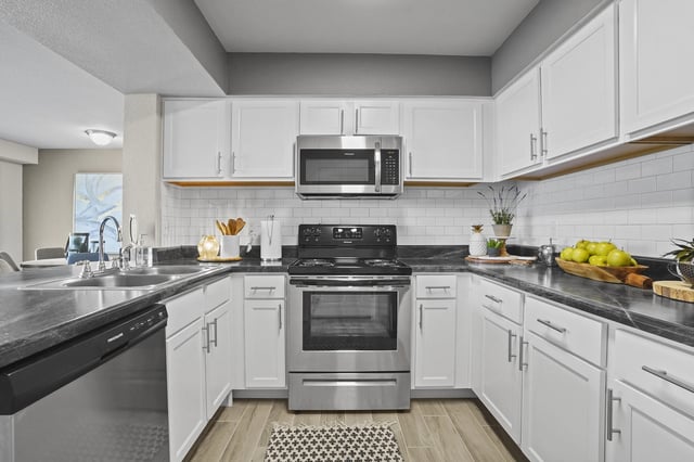 Modern kitchen with white cabinets, stainless steel appliances, and subway tile backsplash.