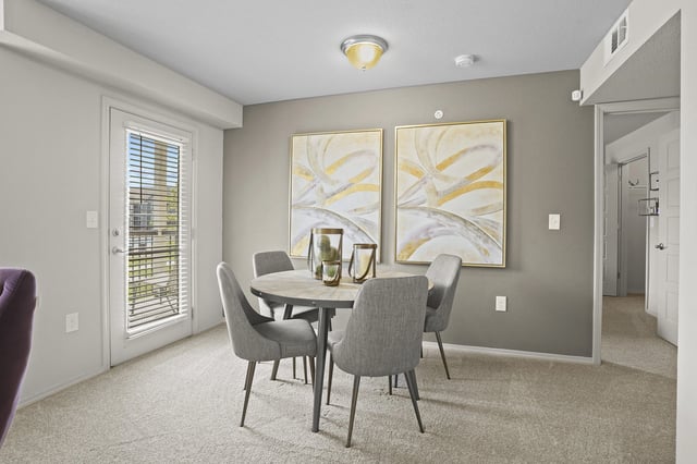 A dining room with a table and chairs.