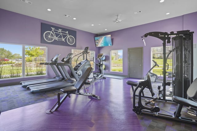 Interior view of a fitness center with treadmills, an elliptical, and a weight machine.