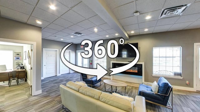 Interior communal lounge area with sofas, chairs, fireplace, and 360 degree view.