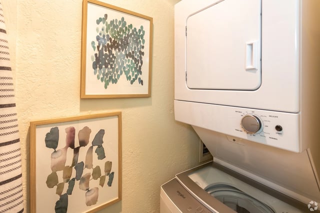Stackable washer and dryer with abstract art on the wall