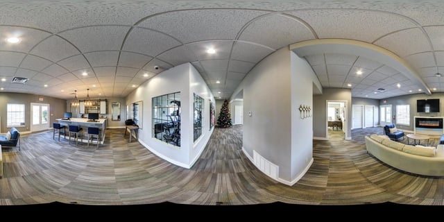 Community lounge with seating, bar, gym, and fireplace.