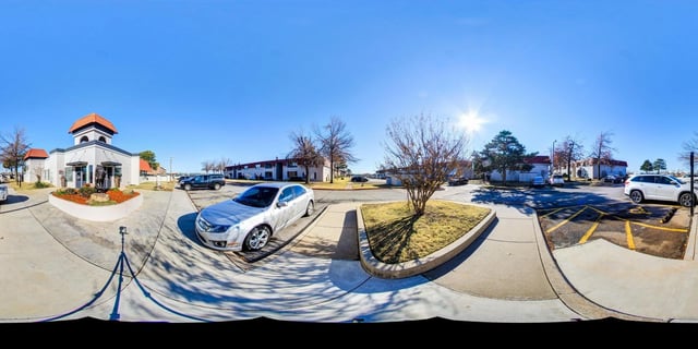 Exterior view of apartment buildings and office with parking lot.