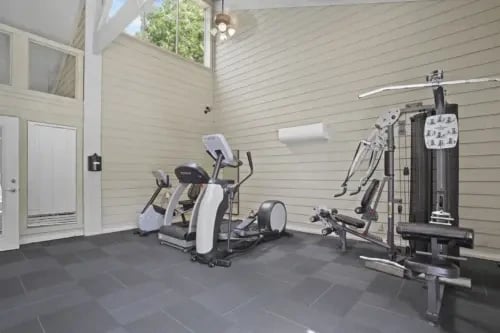 Indoor community gym with cardio machines and weight equipment.