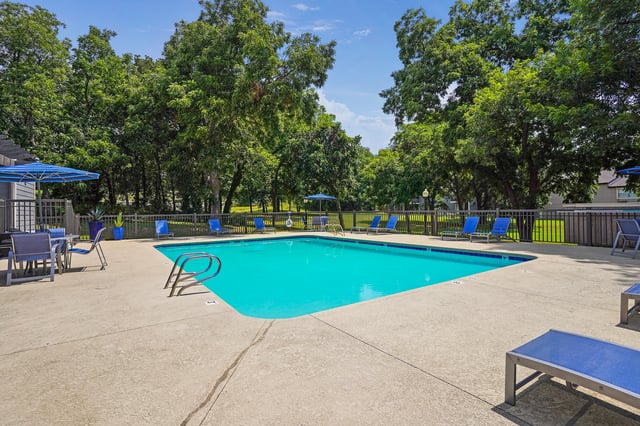 An inviting swimming pool with lounge chairs and umbrellas on a sunny day.
