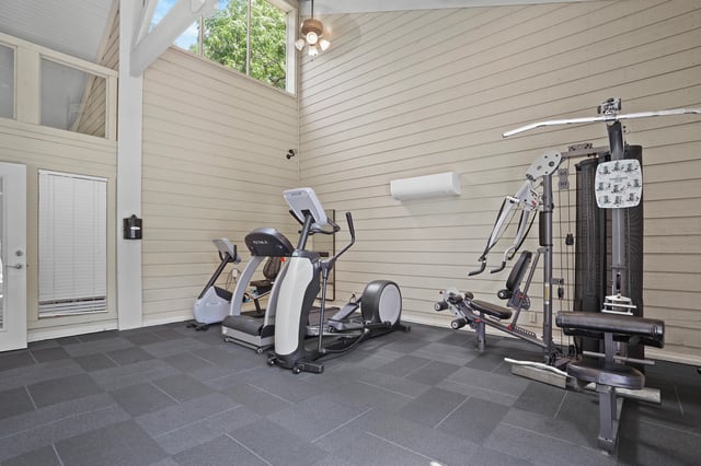 Gym with treadmills, elliptical, and weight machine.