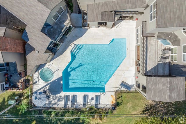 Aerial view of a swimming pool and hot tub area at an apartment complex.