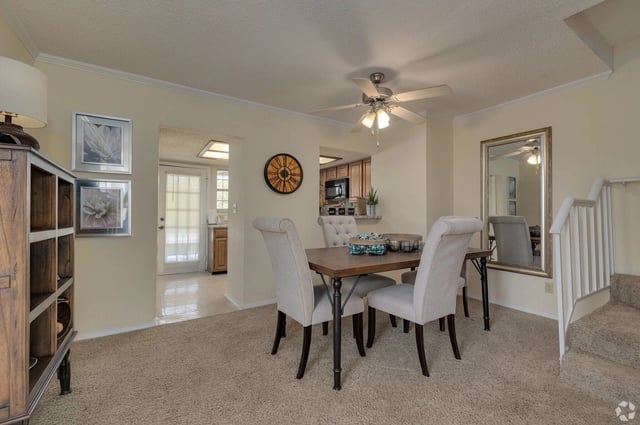 Dining room with table and chairs, leading to a kitchen.