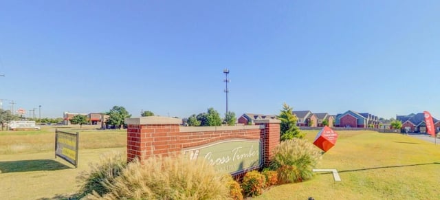 Signage for Cross Timber Apartment Homes with a brick monument and landscaping.