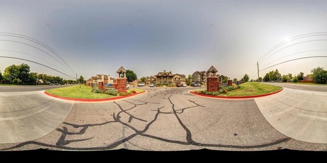 Entrance to a multifamily property with brick pillars and signage.