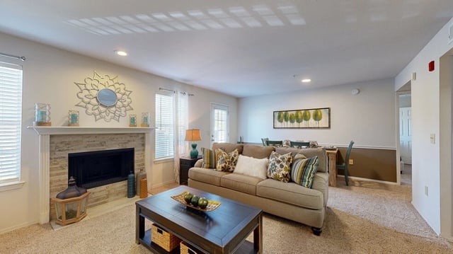 Living room with fireplace, sofa, and dining area