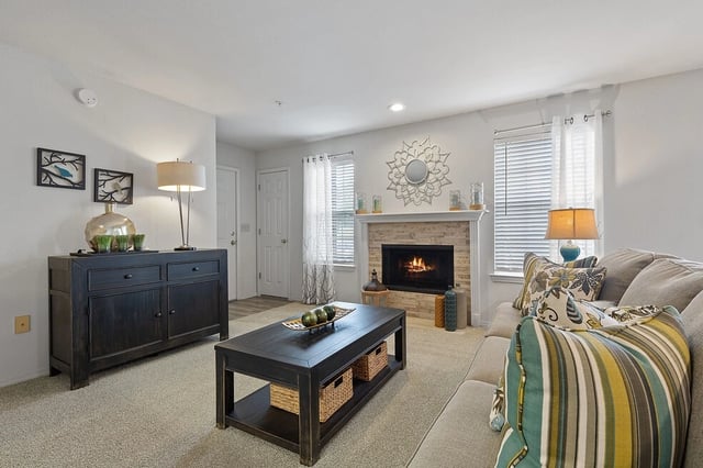 Living room with a fireplace, sofa, coffee table, and a sideboard.