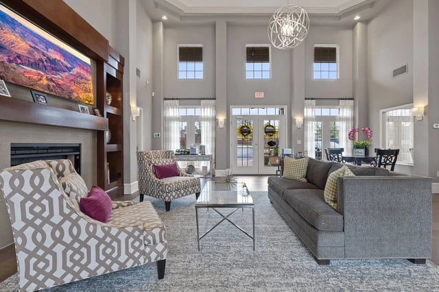 Luxurious communal lounge area with fireplace, large screen TV, comfortable seating, and a chandelier.